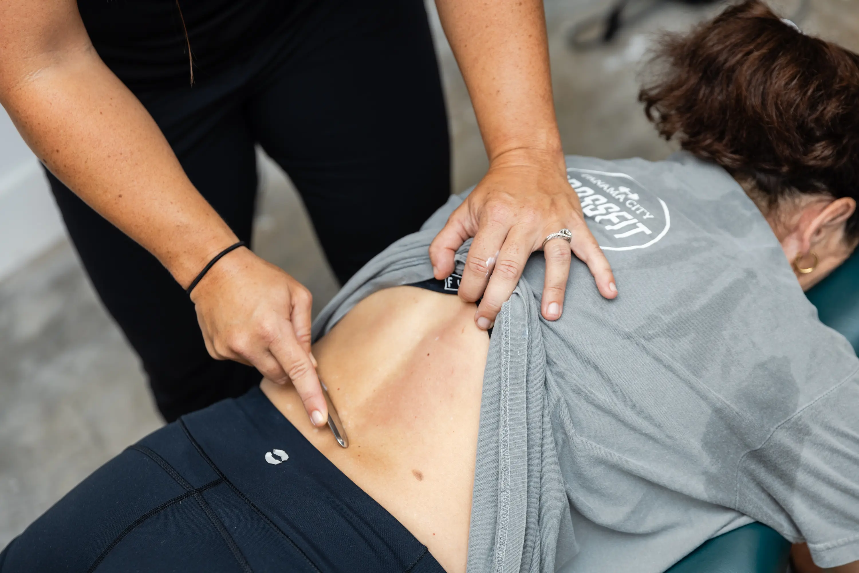 A person is getting their back examined by an acupuncturist.